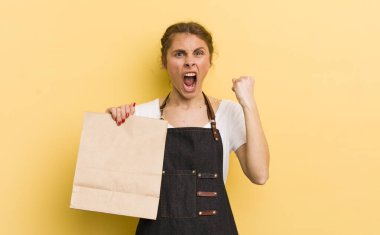 Genç ve güzel bir kadın sinirli bir ifadeyle agresif bir şekilde bağırıyor. Fast food kurye konsepti