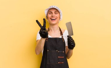 Gülümseyen ve mutlu görünen genç, güzel bir kadın zafer ya da huzur simgesi. Kasap konsepti