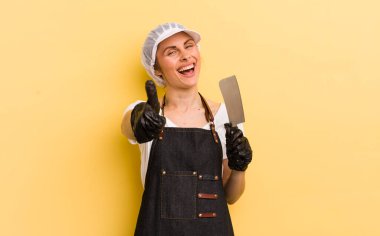 Genç ve güzel bir kadın gururlu, olumlu gülümsüyor. Kasap konsepti