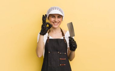 Genç ve güzel bir kadın kendini mutlu hissediyor. Onayını iyi bir hareketle gösteriyor. Kasap konsepti