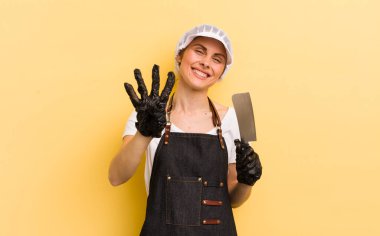 Genç, güzel bir bayan gülümsüyor ve arkadaş canlısı görünüyor, dört numarayı gösteriyor. Kasap konsepti