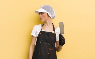 Profil görünümlü genç, güzel bir kadın hayal kuruyor ya da hayal kuruyor. Kasap konsepti