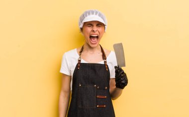 Genç ve güzel bir kadın agresif bir şekilde bağırıyor, çok kızgın görünüyor. Kasap konsepti