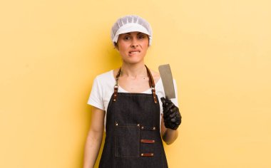 Genç, güzel bir kadın kafası karışmış ve şaşkın görünüyor. Kasap konsepti