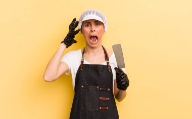 Genç ve güzel bir kadın ellerini havaya kaldırarak çığlık atıyor. Kasap konsepti