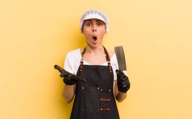 Genç ve güzel bir kadın şok olmuş ve şaşırmış hissediyor. Kasap konsepti