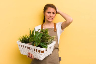 Genç ve güzel bir kadın gergin, endişeli ya da korkmuş hissediyor. Elleri başının üstünde. bitki kavramı