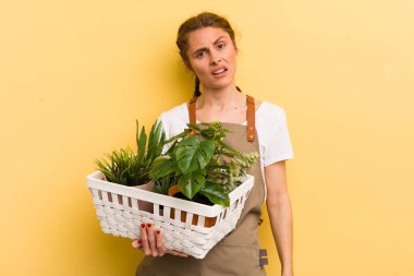 Genç ve güzel bir kadın şaşkın ve şaşkın hissediyor. bitki kavramı