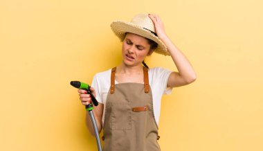 Genç, güzel bir kadın kafası karışmış, kafası karışmış, kaşınıyor. gardering konsepti