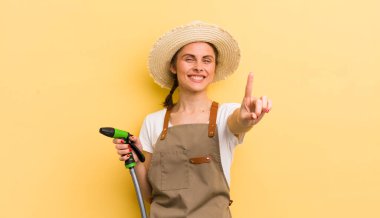 Genç ve güzel bir kadın gururla gülümsüyor ve kendinden emin bir numara oluyor. gardering konsepti