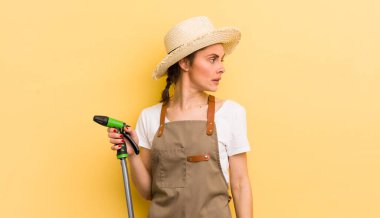 Profil görünümlü genç, güzel bir kadın hayal kuruyor ya da hayal kuruyor. gardering konsepti