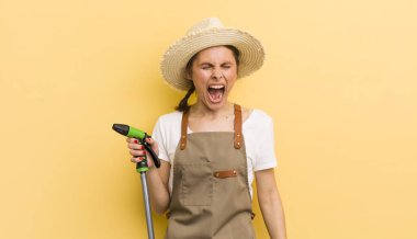 Genç ve güzel bir kadın agresif bir şekilde bağırıyor, çok kızgın görünüyor. gardering konsepti