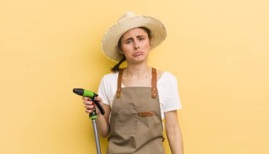 Genç, güzel bir kadın üzgün ve mızmızlanıyor. Mutsuz bir bakışı var ve ağlıyor. gardering konsepti