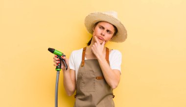 Genç, güzel bir kadın düşünüyor, kuşkulu ve şaşkın hissediyor. gardering konsepti