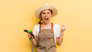 Genç ve güzel bir kadın sinirli bir ifadeyle agresif bir şekilde bağırıyor. gardering konsepti