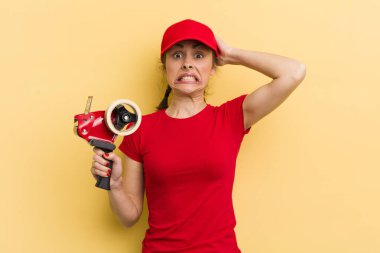 Genç ve güzel bir kadın gergin, endişeli ya da korkmuş hissediyor. Elleri başının üstünde. paketleyici kavramı