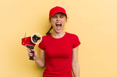 Genç ve güzel bir kadın agresif bir şekilde bağırıyor, çok kızgın görünüyor. paketleyici kavramı