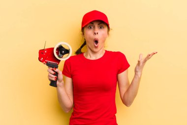 Genç ve güzel bir kadın şok olmuş ve şaşırmış hissediyor. paketleyici kavramı