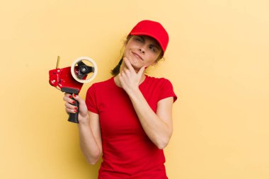 Genç, güzel bir kadın düşünüyor, kuşkulu ve şaşkın hissediyor. paketleyici kavramı