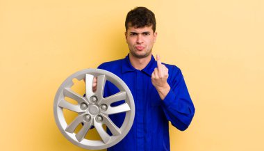 Genç ve yakışıklı bir adam sinirli, sinirli, asi ve agresif hissediyor. araba tamircisi konsepti