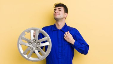 Genç yakışıklı adam kibirli, başarılı, pozitif ve gururlu görünüyor. araba tamircisi konsepti