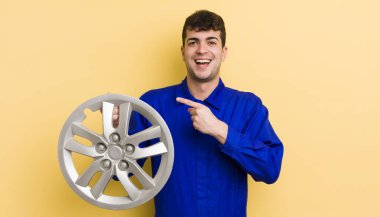 Genç yakışıklı adam heyecanlı ve şaşırmış görünüyor. araba tamircisi konsepti