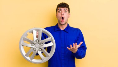 Genç yakışıklı adam, inanılmaz bir sürprizle şaşkına dönmüş ve hayrete düşmüştü. araba tamircisi konsepti