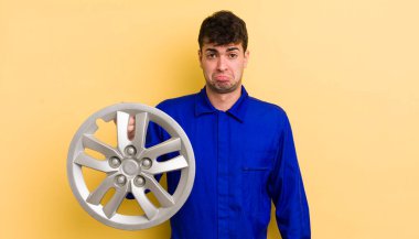 Genç ve yakışıklı bir adam üzgün ve mızmızlanıyor. Mutsuz bir bakışı var ve ağlıyor. araba tamircisi konsepti