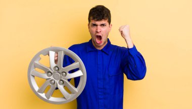 Genç yakışıklı adam sinirli bir ifadeyle agresif bir şekilde bağırıyor. araba tamircisi konsepti