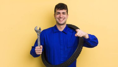 Genç ve yakışıklı bir adam kamerayı işaret ederek seni seçiyor. motor tamircisi kavramı