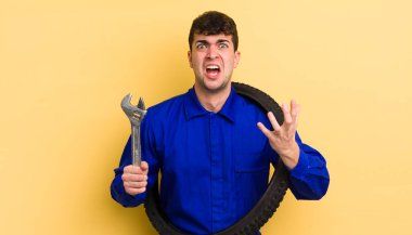 Genç yakışıklı adam umutsuz, sinirli ve stresli görünüyor. motor tamircisi kavramı