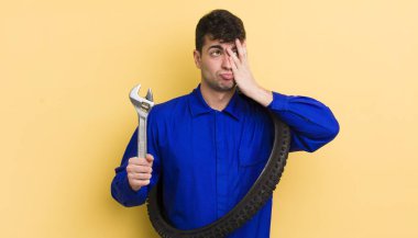 Genç yakışıklı bir adam bıkkın, hayal kırıklığına uğramış ve yorucu bir geceden sonra uykulu hissediyor. motor tamircisi kavramı