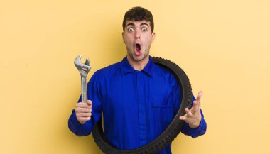 Genç ve yakışıklı bir adam şok olmuş ve şaşırmış hissediyor. motor tamircisi kavramı