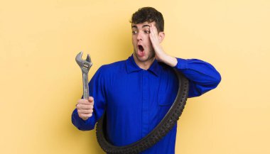 Genç yakışıklı adam mutlu, heyecanlı ve şaşırmış hissediyor. motor tamircisi kavramı