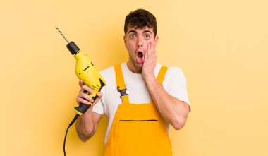 Genç ve yakışıklı bir adam şok olmuş ve korkmuş hissediyor. Tamirci ve matkap konsepti