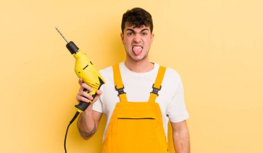 Genç ve yakışıklı bir adam tiksinmiş ve sinirlenmiş hissediyor ve dilini dışarı çıkarıyor. Tamirci ve matkap konsepti