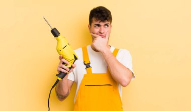 Genç yakışıklı düşünen, kuşkulu ve kafası karışık bir adam. Tamirci ve matkap konsepti