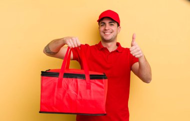 Genç ve yakışıklı bir adam gururlu, olumlu gülümsüyor. Pizza kurye konsepti