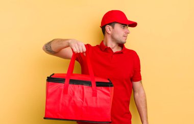 Profilde genç yakışıklı bir adam hayal kuruyor, hayal kuruyor ya da hayal kuruyor. Pizza kurye konsepti