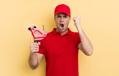 Genç yakışıklı adam sinirli bir ifadeyle agresif bir şekilde bağırıyor. paketleyici kavramı