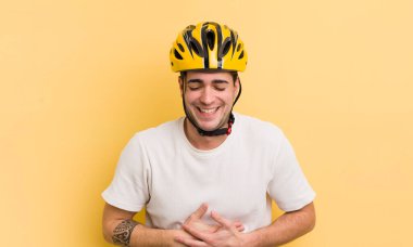 Genç yakışıklı bir adam komik bir şakaya yüksek sesle gülüyor. motor konsepti