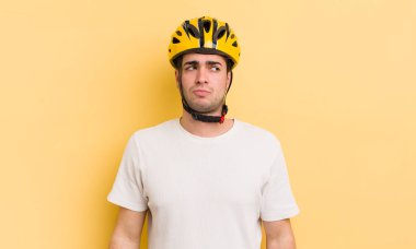 Genç ve yakışıklı bir adam üzgün, üzgün ya da kızgın hissediyor ve yan tarafa bakıyor. motor konsepti