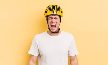 Genç yakışıklı adam agresif bir şekilde bağırıyor, çok kızgın görünüyor. motor konsepti