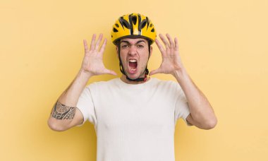 Genç yakışıklı adam ellerini havaya kaldırarak çığlık atıyor. motor konsepti