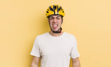 Genç ve yakışıklı bir adam tiksinmiş ve sinirlenmiş hissediyor ve dilini dışarı çıkarıyor. motor konsepti