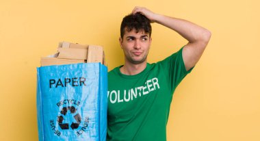 Kafası karışmış, kafası karışmış, kaşınan genç yakışıklı bir adam.