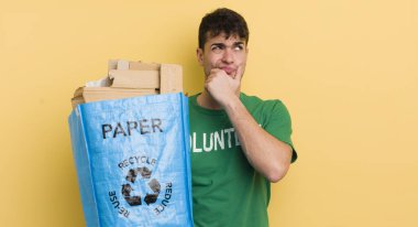 Genç yakışıklı adam düşünüyor, kuşkulu ve şaşkın hissediyor.