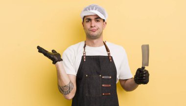 Genç yakışıklı adam şaşkın, şaşkın ve şüpheci hissediyor. Kasap konsepti