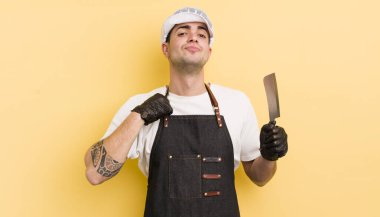 Genç yakışıklı adam kibirli, başarılı, pozitif ve gururlu görünüyor. Kasap konsepti