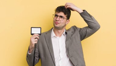 Kafası karışmış, kafası karışmış, kaşınan genç, yakışıklı bir adam. VIP geçiş konsepti